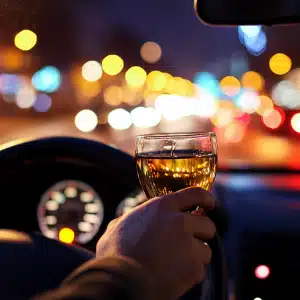 A man driving a car while drinking