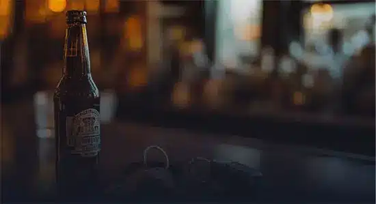 Beer Bottle Kept on a Table with Car keys nearby - Drunk Driving