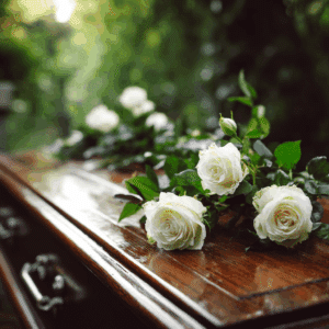 wooden coffin with white roses placed on top